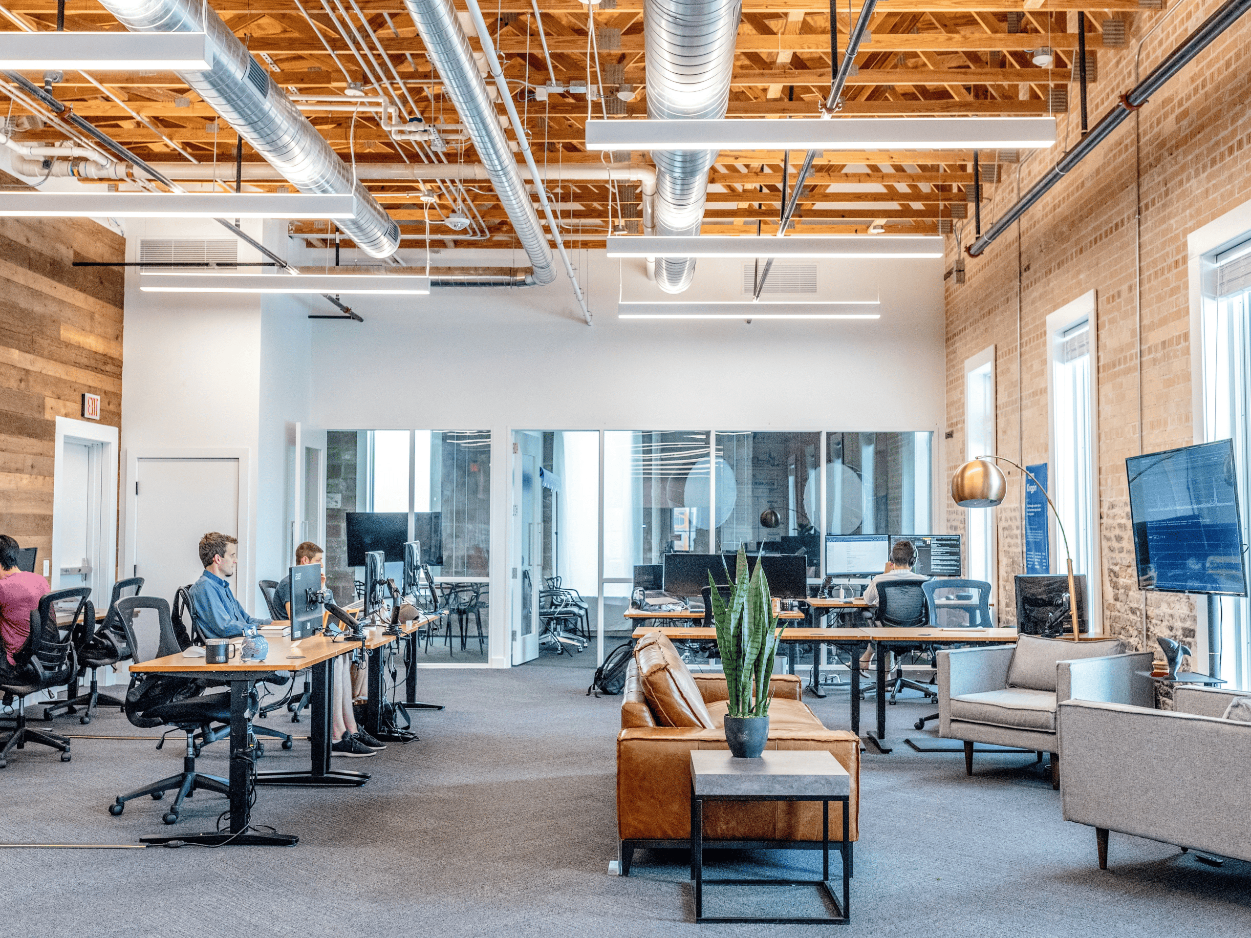 Modern open-plan office with desks, chairs, and employees working.